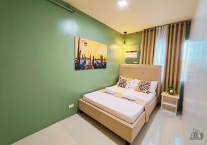 a bedroom with a bed and a green wall at Puerto Princesa Luxury 1BR Rental Homes with FREE Gym, Pool & Parking - B1 5Pearl in Puerto Princesa City +156 photos