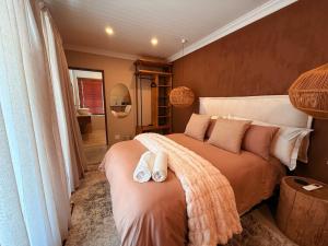 a bedroom with a bed with two towels on it at Self Check-in River View Suite in Wellington