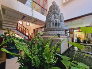 a statue in the middle of a room with plants at Maison Saiko Angkor Boutique in Siem Reap
