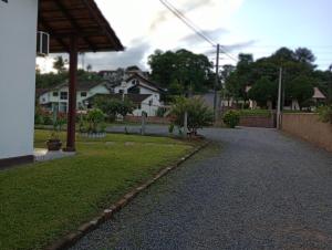 a walkway in a yard with houses in the background at Cantinho aconchegante in Timbó