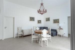 Una sala de estar con una mesa y sillas y un sofá. en Villa Magliese, en Maglie