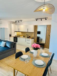 a living room with a wooden table and a kitchen at Central Grand Apartment in Timişoara