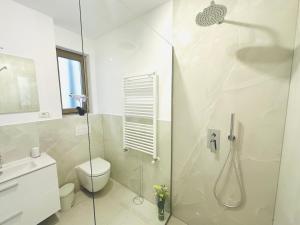 a white bathroom with a shower and a toilet at Central Grand Apartment in Timişoara +26 photos