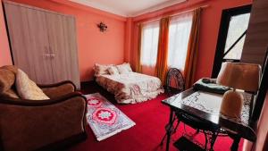 a red room with a bed and a desk at Chomolungma Paribesh Trimarg in Khadkagaon