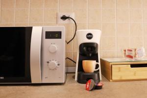 a coffee maker sitting next to a microwave on a counter at A Casa di Rocco in Rome +33 photos