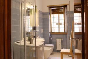 a blue bathroom with a toilet and a sink at A Casa di Rocco in Rome