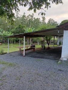 a picnic table under a canopy in a park at Cantinho do lar in Timbó