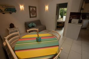 ein Zimmer mit einem Tisch und einem Wohnzimmer in der Unterkunft Pinpirinia min 3 nuits in Guéthary