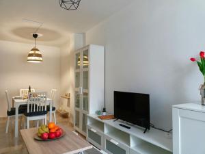 a living room with a television and a table with a bowl of fruit at O Soño de Santiago - Casa rural Mondoñedo, Galicia in Mondoñedo