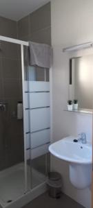 a white bathroom with a sink and a shower at Mirador de Peña La Estrella in Ortigosa del Monte