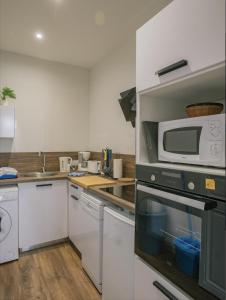 a kitchen with a microwave and a stove at Appartement refait à neuf avec cachet de l'ancien in Saumur