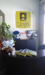 a desk in an office with a sign on the wall at Logis Drom'sud Hotel in Donzère