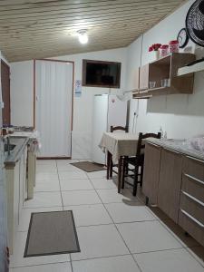 a kitchen with a table and a refrigerator at Cantinho do lar in Timbó