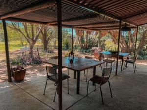 a wooden table and chairs under a pavilion at Die Woestynroos Gastehuis in Isidule