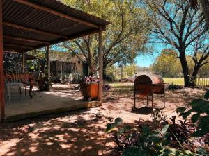 a patio with a grill and a table and chairs at Die Woestynroos Gastehuis in Isidule