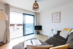 a living room with a couch and a large window at Sunny 1 bedroom apartment, Ocean house, East wittering in East Wittering