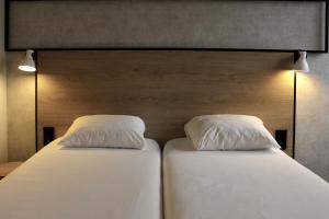 Rúm í herbergi á ibis Dijon Sud