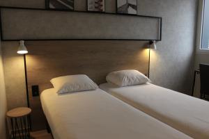 Rúm í herbergi á ibis Dijon Sud