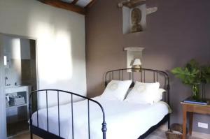a bedroom with a bed with white sheets and pillows at Villa charmante Beaumes-de-Venise in Beaumes-de-Venise
