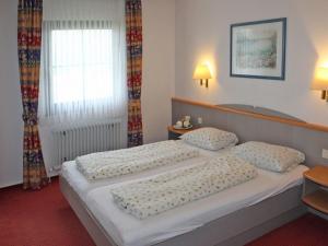 une chambre avec deux lits et une fenêtre dans l'établissement Ferienhaus Nr 42, Kategorie Komfort, Feriendorf Hochbergle, Allgäu, à Lechbruck am See
