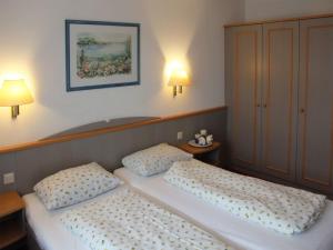 - deux lits jumeaux dans une chambre avec deux lampes dans l'établissement Ferienhaus Nr 42, Kategorie Komfort, Feriendorf Hochbergle, Allgäu, à Lechbruck am See