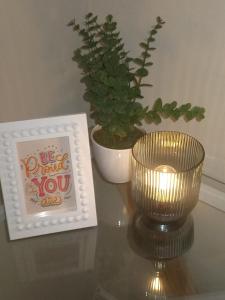 a table with a candle and a picture and a plant at Simple stay in East London