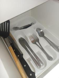 a plastic tray with utensils in a drawer at Simple stay in East London