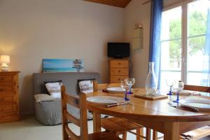 Un comedor con mesa y sillas de madera. en Appartement 2 pièces 4 couchages Dolus d'Oléron DDO000-008, en Dolus d'Oléron