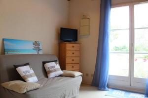 1 dormitorio con sofá, TV y ventana en Appartement 2 pièces 4 couchages Dolus d'Oléron DDO000-008, en Dolus d'Oléron 4 fotos más