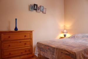 1 dormitorio con 1 cama y vestidor con reloj en la pared en Appartement 2 pièces 4 couchages Dolus d'Oléron DDO000-008, en Dolus d'Oléron