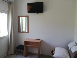 a room with a table and a tv on the wall at Apartmani Kristina in Drvenik