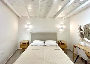 a bedroom with a bed with two night stands and two tables at Ano Syros Orient in Ano Syros
