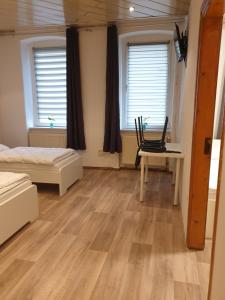 a bedroom with a bed and a desk and windows at Monteurwohnung bei Nina EGR in Zeitz