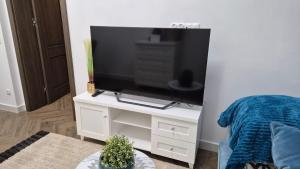 a living room with a tv on a white stand at APARTAMENT JARACZA 28 nr 4 in Słupsk