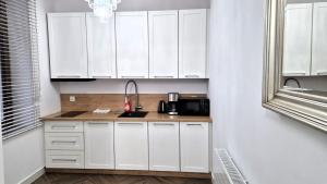 a kitchen with white cabinets and a sink at APARTAMENT JARACZA 28 nr 4 in Słupsk +11 photos
