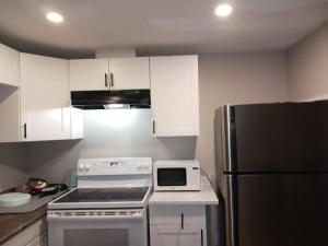 a kitchen with a stove and a refrigerator at Kitchener -WLU BNB-Minutes To University of Waterloo, Conestoga College,Buses,Airport in Waterloo