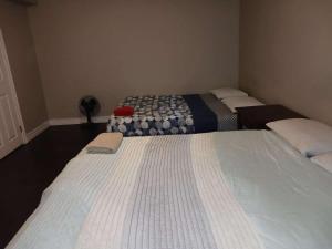 two beds in a small room with at Kitchener -WLU BNB-Minutes To University of Waterloo, Conestoga College,Buses,Airport in Waterloo