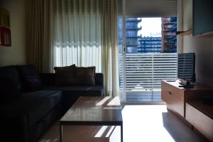 a living room with a couch and a large window at Beachfront Apartment with Pool and Garden S Abanell Blanes in Blanes