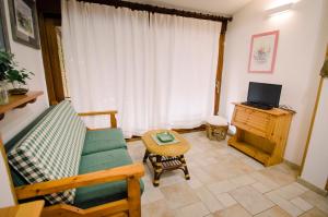 a living room with a couch and a television at Villetta schiera, 150m dal mare in Badesi
