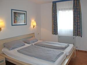 un grand lit dans une chambre avec une fenêtre dans l'établissement Ferienhaus Nr 46, Kategorie Komfort L, Feriendorf Hochbergle, Allgäu, à Lechbruck am See