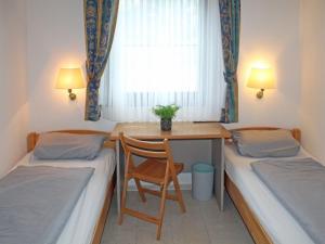 une chambre avec deux lits, un bureau et une fenêtre dans l'établissement Ferienhaus Nr 46, Kategorie Komfort L, Feriendorf Hochbergle, Allgäu, à Lechbruck am See