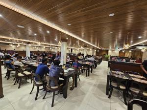 a group of people sitting at tables in a restaurant at Saveira Colombo in Colombo