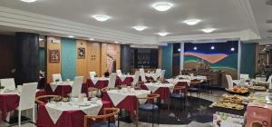 a dining room with white tables and chairs with red napkins at Hotel Casagrande in Feltre