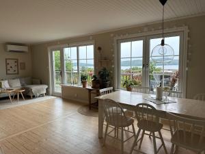 a dining room and living room with a table and chairs at house with a view, with a small boat in the lake in Huskvarna