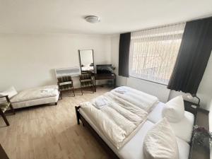 フロートーにあるHotel Ellermannのベッドと机と鏡のある寝室