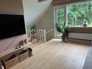 a living room with a flat screen tv on a wall at house with a view, with a small boat in the lake in Huskvarna