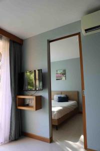 - un miroir dans une chambre avec un lit et une télévision dans l'établissement Two Room MiamiStyle Perfect for Digital Nomads, à Ban Saiyuan (1)