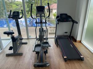 une salle de sport avec trois vélos d'exercice dans une pièce dans l'établissement Two Room MiamiStyle Perfect for Digital Nomads, à Ban Saiyuan (1)