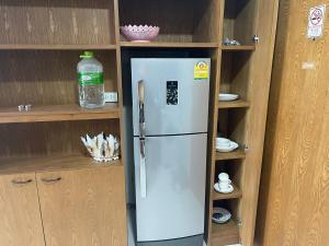 un réfrigérateur dans une cuisine avec des armoires en bois dans l'établissement Two Room MiamiStyle Perfect for Digital Nomads, à Ban Saiyuan (1)