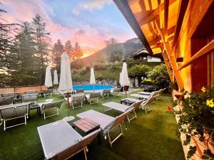 a group of chairs and umbrellas next to a pool at Hotel Rio Bianco in Panchià